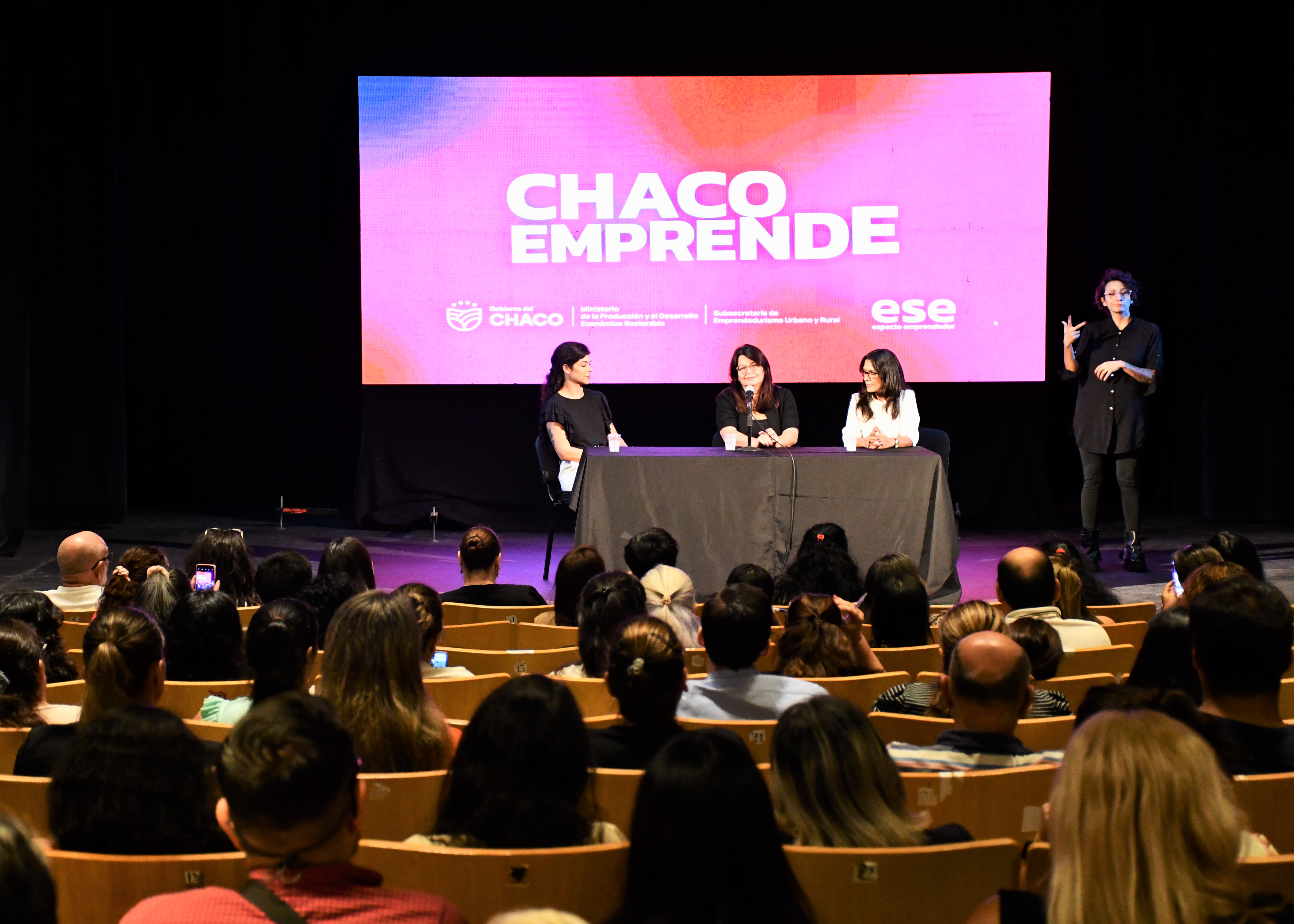 foto-de-gente-sentada-mirando-al-frente-a-tres-personas-en-panel-hablando-69fc794504a93088808876.jpg