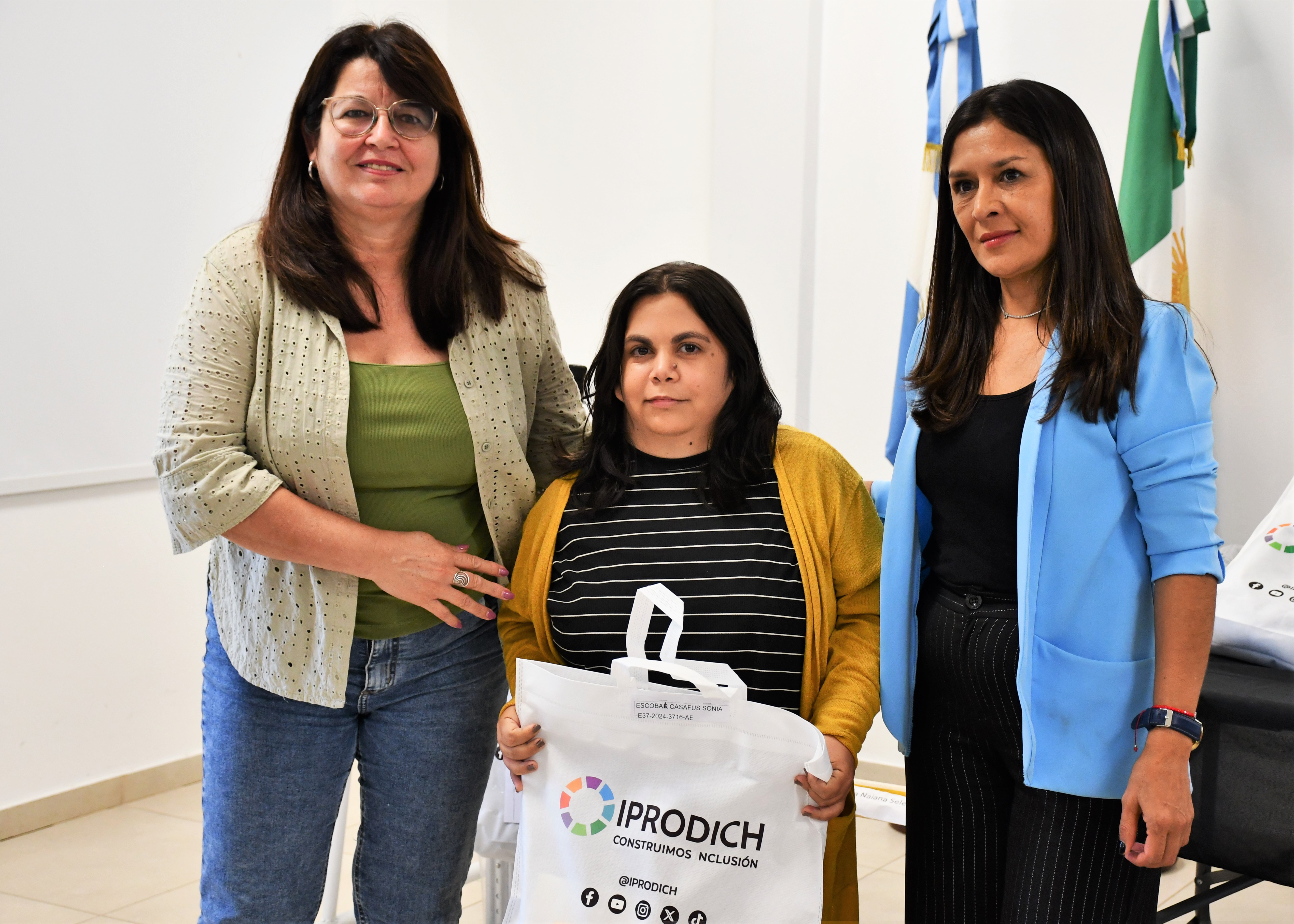 tres-personas-frente-a-camara-una-de-ellas-sosteniendo-una-bolsa-con-el-logo-del-iprodich-6901ed97acd21435383628.jpg